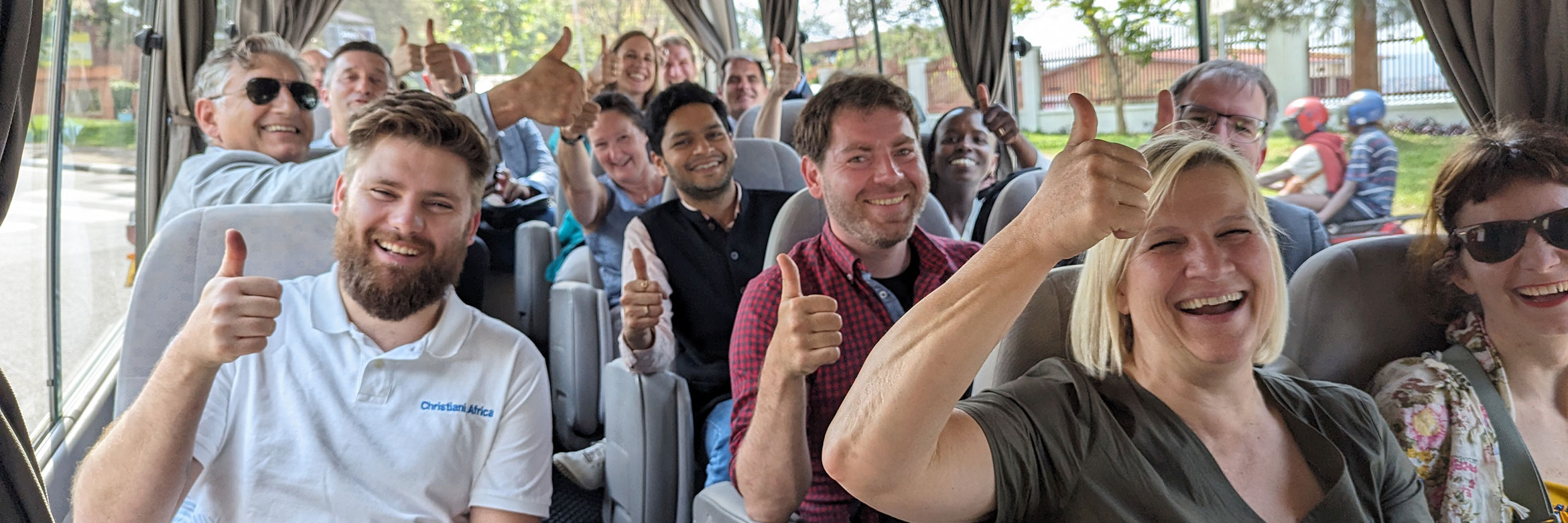 Menschen in einem Bus heben die Hände mit erhobenem Daumen