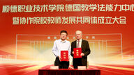 ein chinesischer und ein deutscher Mann halten Urkunden in die Kamera