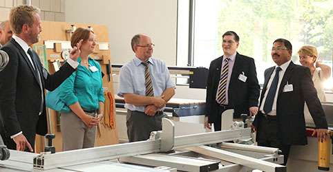 Delegation in einer Halle mit Handwerker-Zubehör