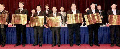 Gruppenbild: Männer halten goldfarbene Schilder in den Händen
