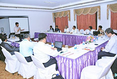 Blick in einen Raum mit mehreren Konferenzteilnehmern an Tischen