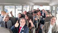Delegation sits on the bus and everyone puts their thumbs in the air