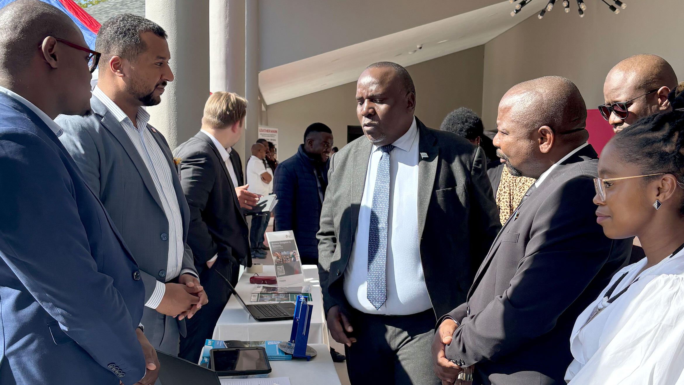 several German and African people talk to each other at an information stand